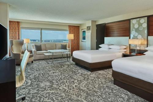 亚特兰大亚特兰大机场希尔顿酒店的酒店客房,设有两张床和一张沙发