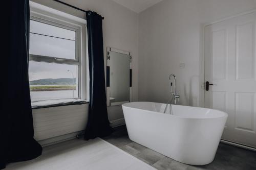 罗西斯波因特Sligo Bay Lodge的带窗户的浴室内的白色浴缸