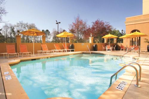 亚特兰大Doubletree Suites by Hilton at The Battery Atlanta的一个带椅子和遮阳伞的大型游泳池