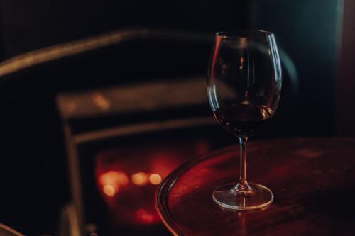 罗西斯波因特Sligo Bay Lodge的坐在壁炉旁的桌子上喝一杯葡萄酒