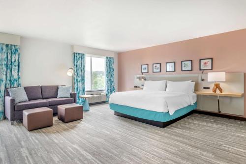 德卢斯亚特兰大东北/昆内特塔糖峰希尔顿花园酒店的酒店客房,配有床和沙发