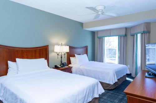 罗维莎Homewood Suites by Hilton Lawrenceville Duluth的酒店客房设有两张床和一台平面电视。