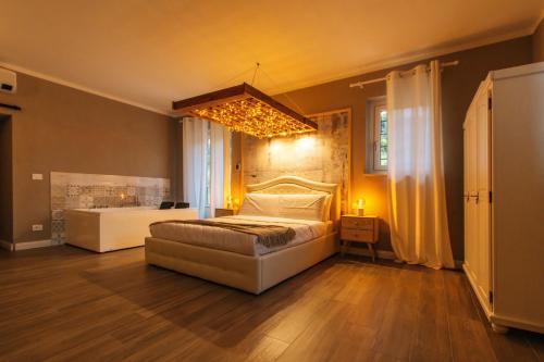 萨卢佐Agriturismo Agli ulivi的一间带一张床和吊灯的大卧室