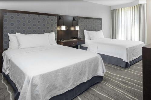 哥伦比亚哥伦比亚希尔顿惠庭套房酒店的酒店客房,配有两张带白色床单的床