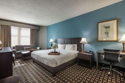 巴尔的摩巴尔的摩柱廊酒店 – 希尔顿逸林酒店的酒店客房设有一张大床和一张书桌。