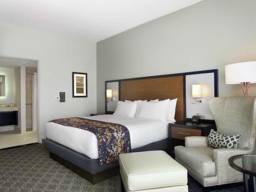 锡达拉皮兹锡达拉皮兹会议中心希尔顿逸林酒店的酒店客房带一张大床和一把椅子