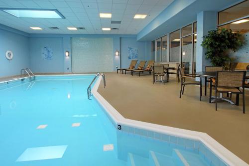纽瓦克纽瓦克希尔顿逸林酒店 的游泳池,带桌椅的房间