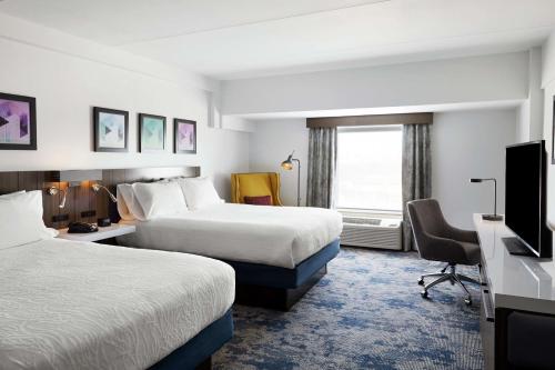尚佩恩尚佩恩/厄巴纳希尔顿花园酒店的酒店客房设有两张床和一台平面电视。