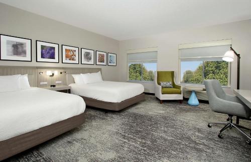 哥伦布哥伦布大学区希尔顿花园酒店的酒店客房 - 带两张床、一张桌子和一把椅子