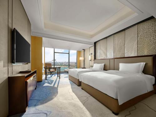 株洲株洲大汉希尔顿酒店的酒店客房设有两张床和一台平面电视。