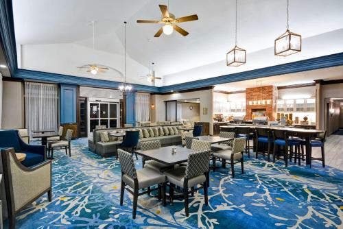 路易斯维尔达拉斯路易斯维尔希尔顿惠庭套房酒店的酒店大堂设有桌椅和酒吧