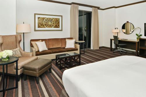 达拉斯达拉斯公园城市希尔顿酒店的配有一张床和一张书桌的酒店客房