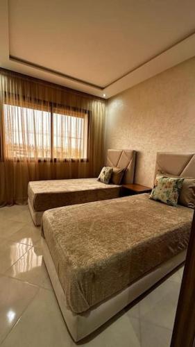 阿加迪尔Appartement Anir的酒店客房设有两张床和窗户。