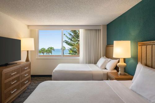 迪尔菲尔德海滩Embassy Suites by Hilton Deerfield Beach Resort & Spa的酒店客房设有两张床和窗户。