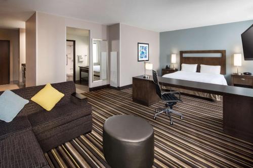 丹佛汉普顿套房酒店及丹佛市区会议中心的大型酒店客房,配有一张床和一张书桌