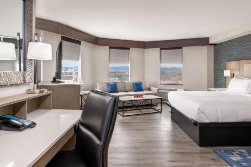 桑顿丹佛索顿希尔顿逸林酒店的配有一张床和一张书桌的酒店客房
