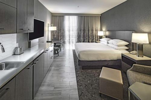 莫德斯托莫德斯托希尔顿逸林酒店的酒店客房设有一张大床和一个厨房。