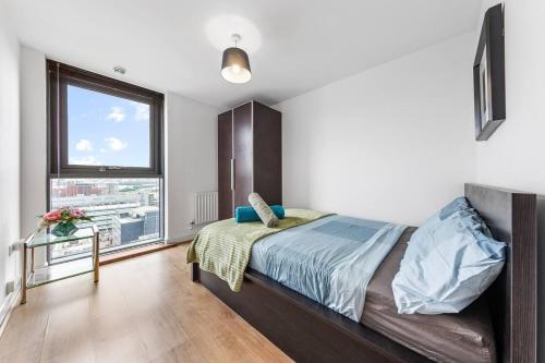 伦敦Mascutstay 2 Beds London skyline view的一间卧室设有一张床和一个大窗户