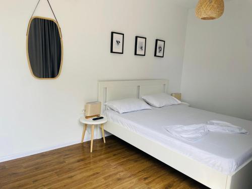 旧瓦马Daro tiny house的卧室配有白色的床和镜子