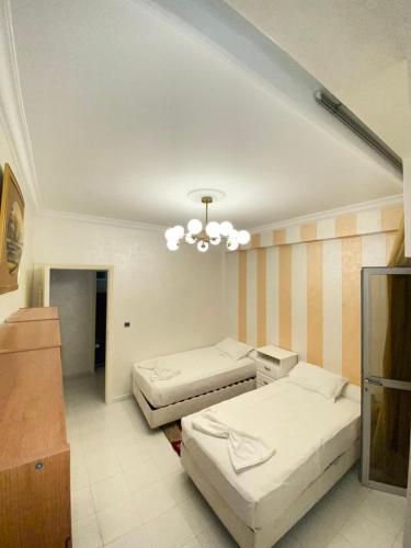 胡塞马Centre ville appartement的一间卧室配有两张床和吊灯。