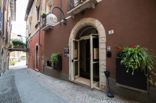 代森扎诺-德尔加达Alessi Hotel Trattoria的入口处,入口处有植物的建筑