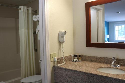 西雅茅斯Sunbird Cape Cod Resort的一间带水槽的浴室和墙上的一部电话