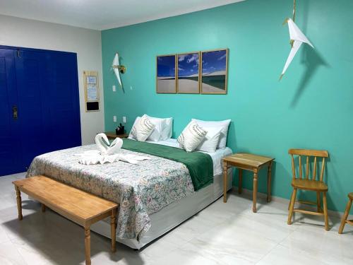 巴雷里尼亚斯Pousada Vila de Charme的一间卧室设有一张床和蓝色的墙壁