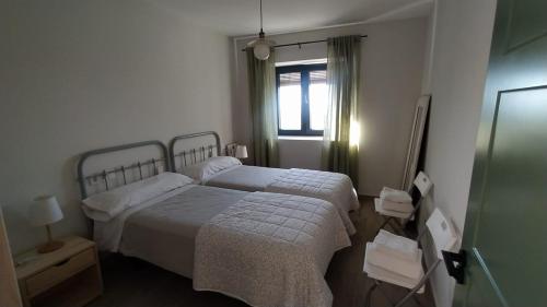 Arroyomolinos de la VeraLa Casa de Abajo的一间卧室设有两张床和窗户。