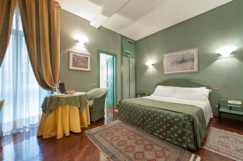 托尔托纳茱莉亚别墅酒店的卧室配有一张床和一张桌子