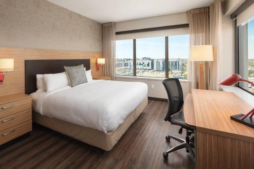 新奥尔良新奥尔良市中心/运河街万豪广场套房酒店的配有一张床、一张书桌和一扇窗户的酒店客房