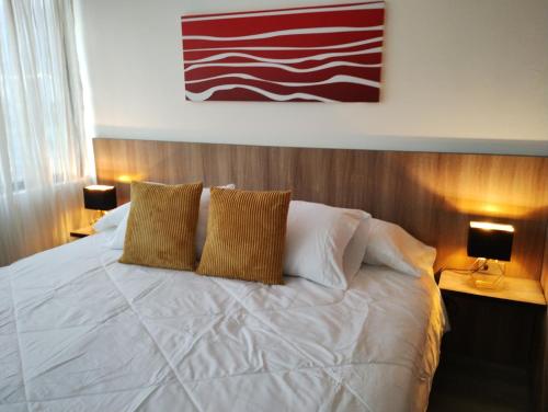 加拉加斯Suite PRIVADA Torre D CCCT Caracas的卧室配有白色床和2个棕色枕头