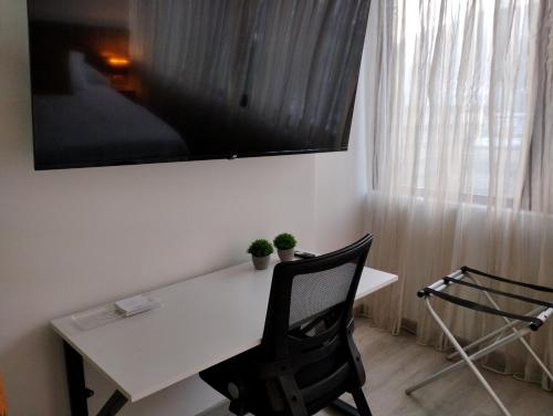 加拉加斯Suite PRIVADA Torre D CCCT Caracas的一张带两把椅子的白色书桌和窗户