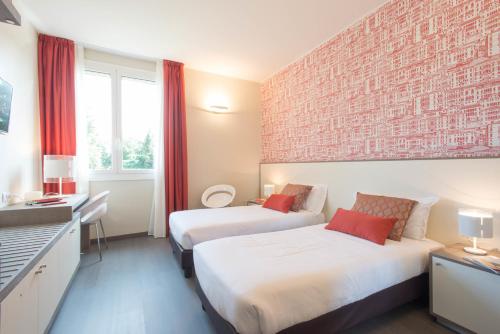 米兰Hotel Tiziano - Gruppo Mini Hotel的砖墙旅馆客房的两张床