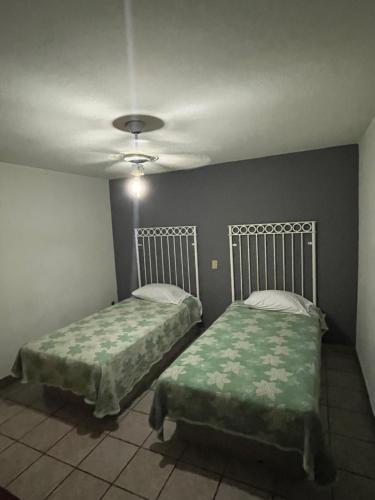圣胡安－德洛斯拉戈斯HOTEL JERUSALEM的一间卧室设有两张床和天花板