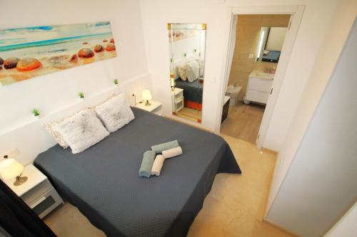 贝尼多姆Panorama Benidorm Torre Montecarlo的一间卧室配有一张床,上面有两条毛巾