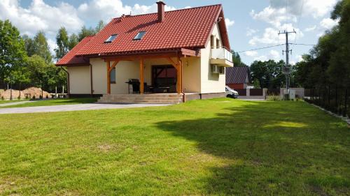 LeszczewekPrzytulisko Leszczewek的院子中一座红色屋顶的小房子
