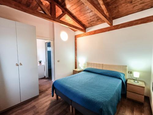 维耶斯泰Il Giunco B&B的一间卧室设有蓝色的床和木制天花板