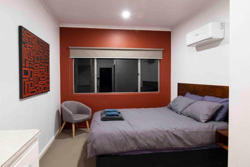 艾利斯斯普林斯4 Bedrooms, 2 Bathrooms in Alice Springs的一间卧室设有一张床和红色的墙壁