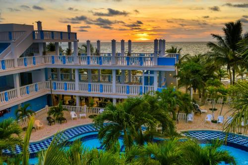 科韦尼亚斯Hotel Isla Mágica的日落时从海滩欣赏度假村美景