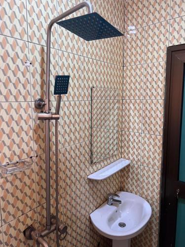 瓦加杜古Ouedraogo Property Management的浴室配有盥洗盆和带镜子的淋浴