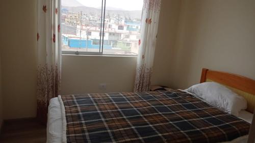 伊洛Apartamento Costa Ilo的一间卧室设有一张床和一个美景窗户。