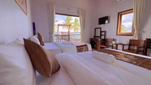 富国The Poplar Resort Phú Quốc的酒店客房设有两张床和一个阳台。