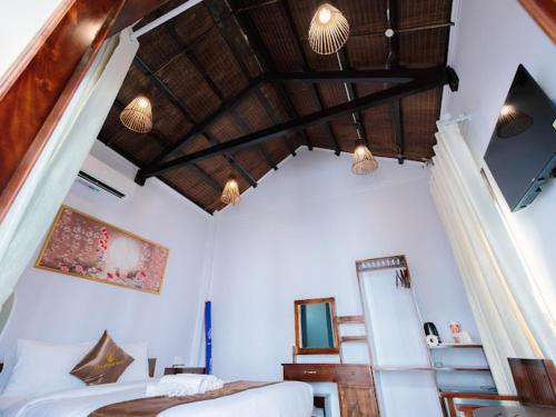 富国The Poplar Resort Phú Quốc的一间卧室设有一张床和木制天花板