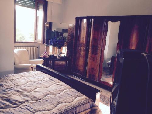 蓬泰代拉Stanza Bellaria的卧室配有床、椅子和窗户。