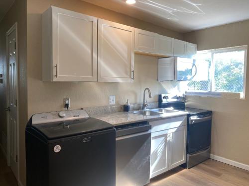 科罗拉多斯普林斯2-bedroom near hwy. 24 & I-25的厨房配有白色橱柜、水槽和洗碗机。