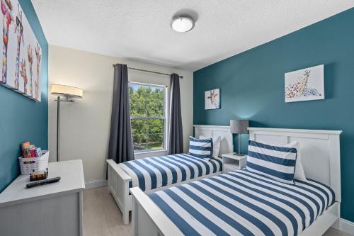 基西米Wish Upon A Splash - Family Villa - 3BR - Private Pool - Disney 4 miles的蓝色墙壁客房的两张床
