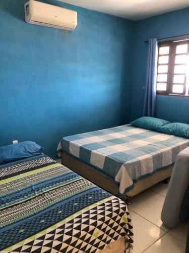 圣若泽-达科罗阿格兰迪Paraíso dos Oliveira的配有两张床铺的蓝色墙壁和窗户