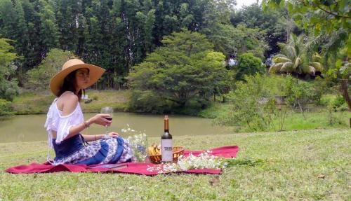 科尔多瓦Casa contenedor Finca la laguna的坐在野餐毯上的女人,带一瓶葡萄酒