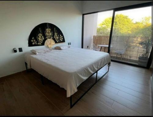 埃斯孔迪多港Casa Dakini en la Punta with pool and ocean view的一间卧室设有一张大床和一个大窗户