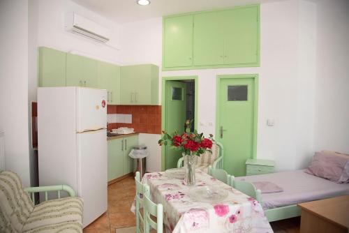 科斯镇STAVROS Studio Apartment in kos town的厨房配有绿色橱柜和鲜花桌